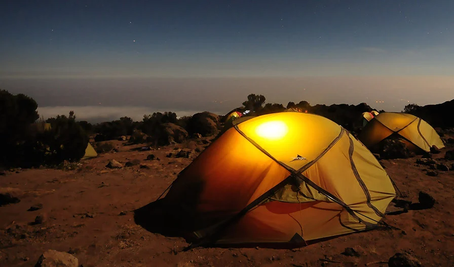 Tents in a desert at night.